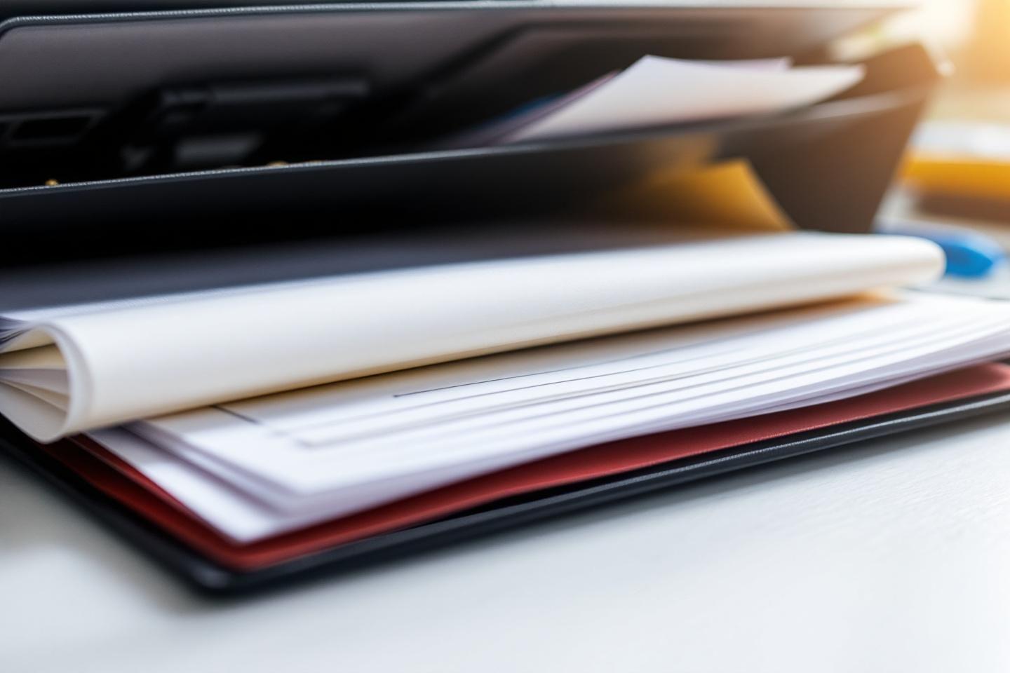 Gros plan sur une pile de documents et dossiers colorés